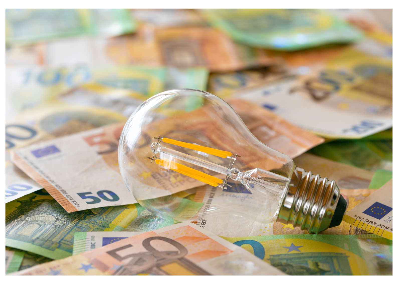 Ampoule posée sur des billets en euros
