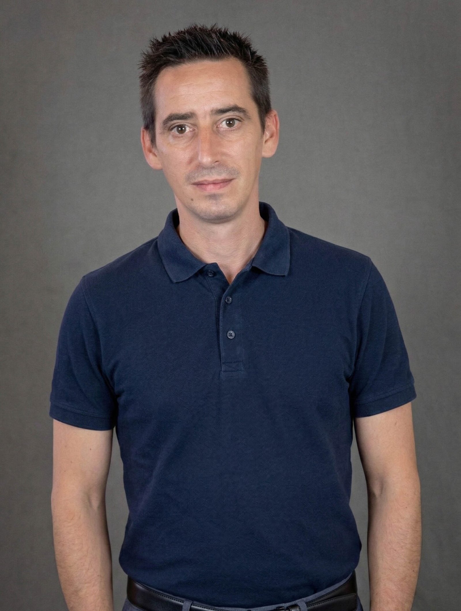 Homme en polo bleu sur fond gris